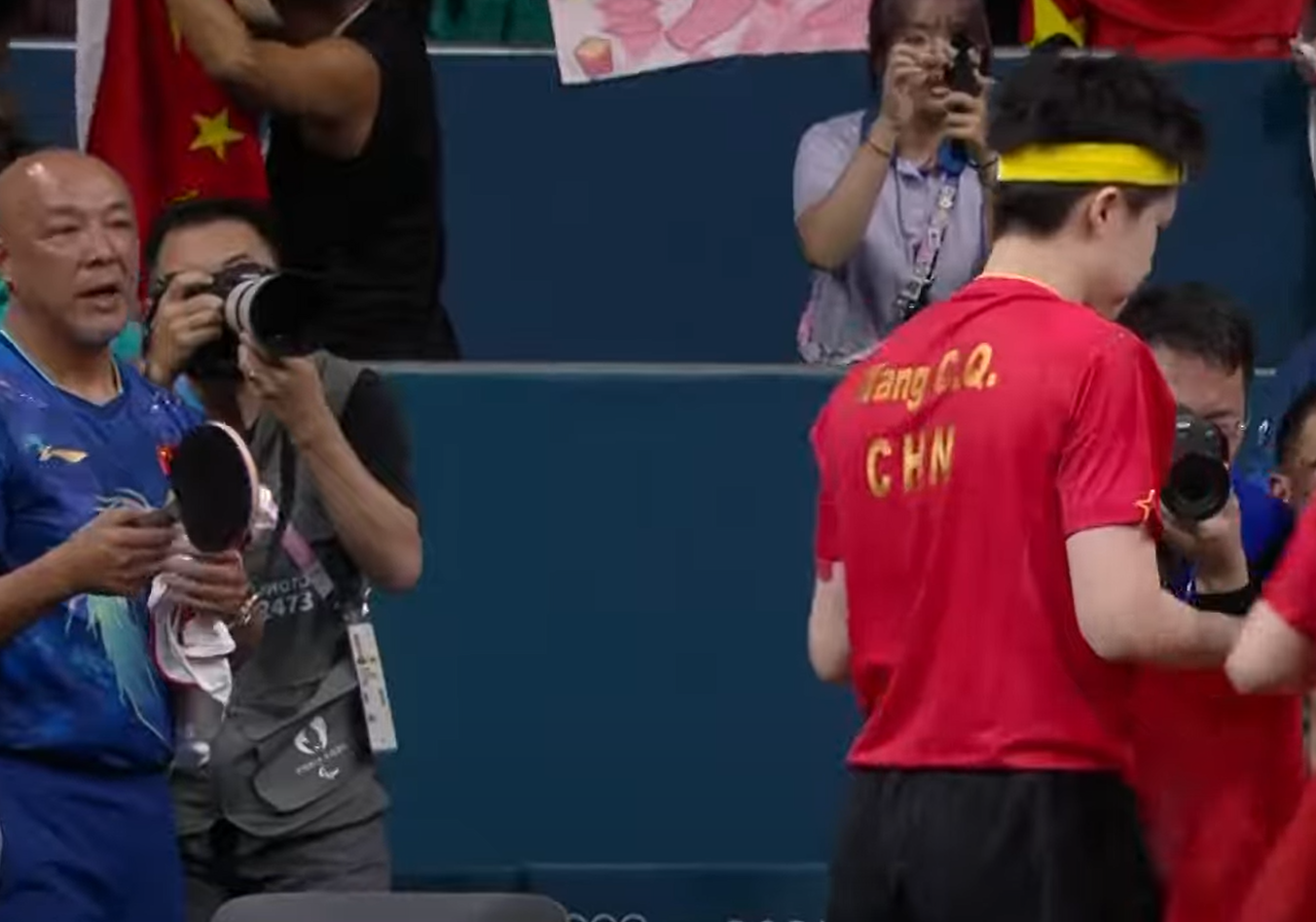 王楚欽得悉球拍被踩斷後神情失落及相當不滿,需教練安撫。(影片截圖)