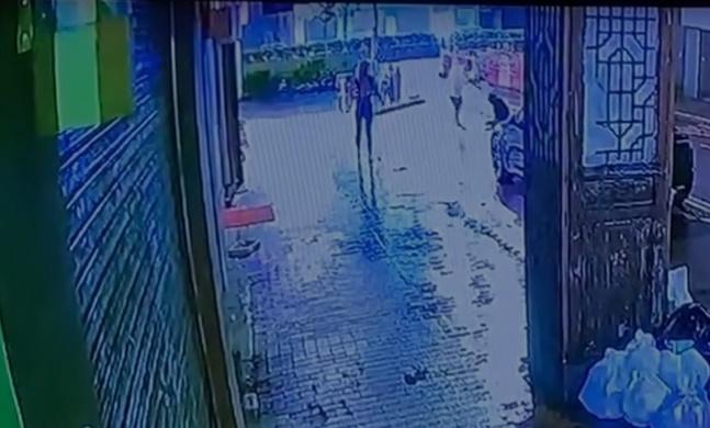 黑衣男跌坐馬路中央,白衫男繼續用錘擊打對方頭部,並罵不住指罵。(網上截圖)