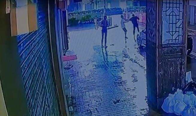 白衫男突然從後用錘狂扑黑衣男後腦,黑衣男連忙走出馬路閃避。(網上截圖)