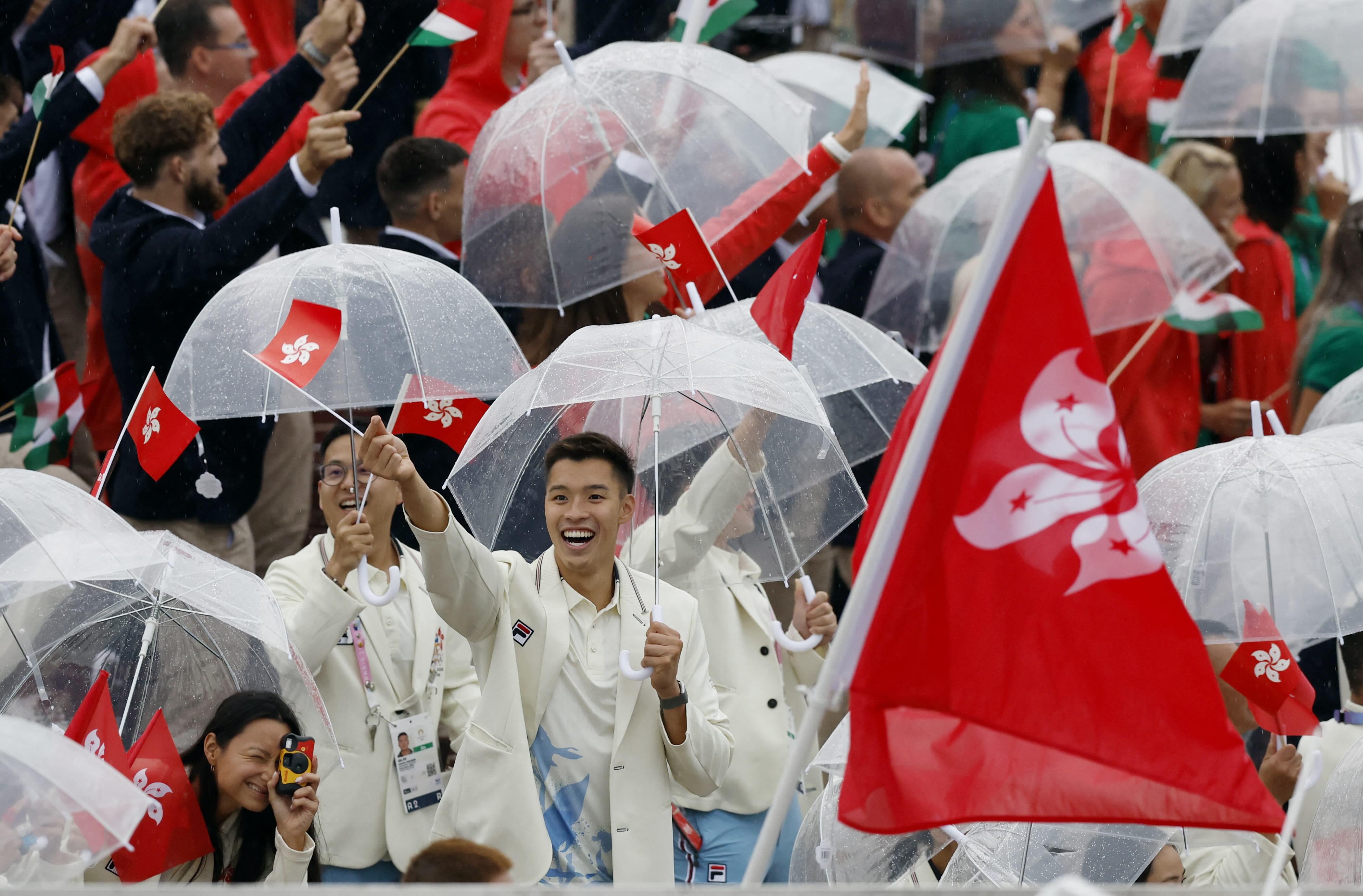 開幕禮現場有雨,故港隊運動員巡遊時都需要撐傘避雨。(路透社)