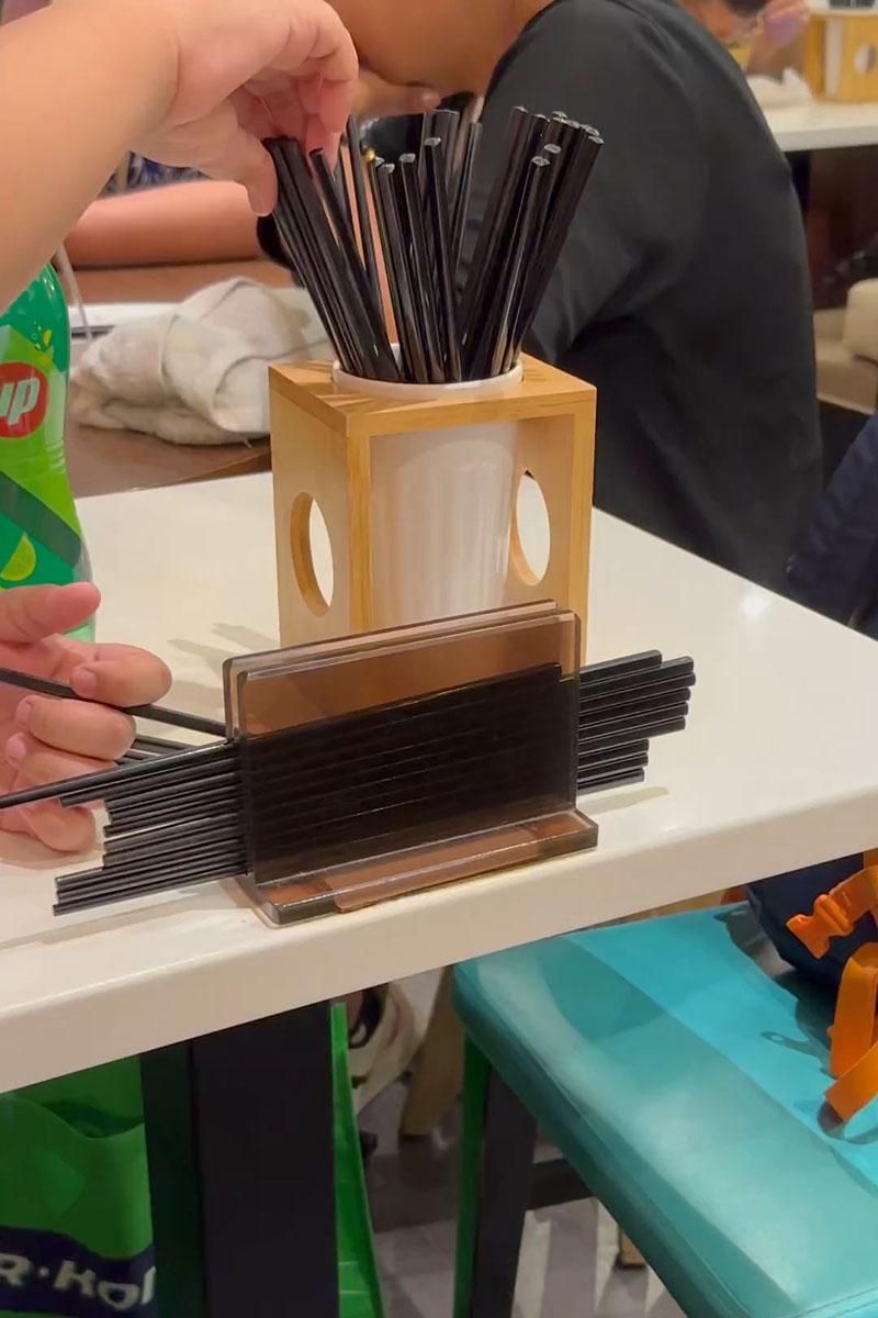 有小孩用食肆自取筷子疊起當玩具,同枱成年人未見阻止。(Threads影片截圖)