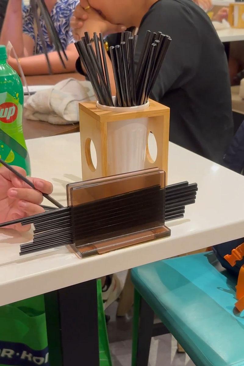 有小孩用食肆自取筷子疊起當玩具,同枱成年人未見阻止。(Threads影片截圖)