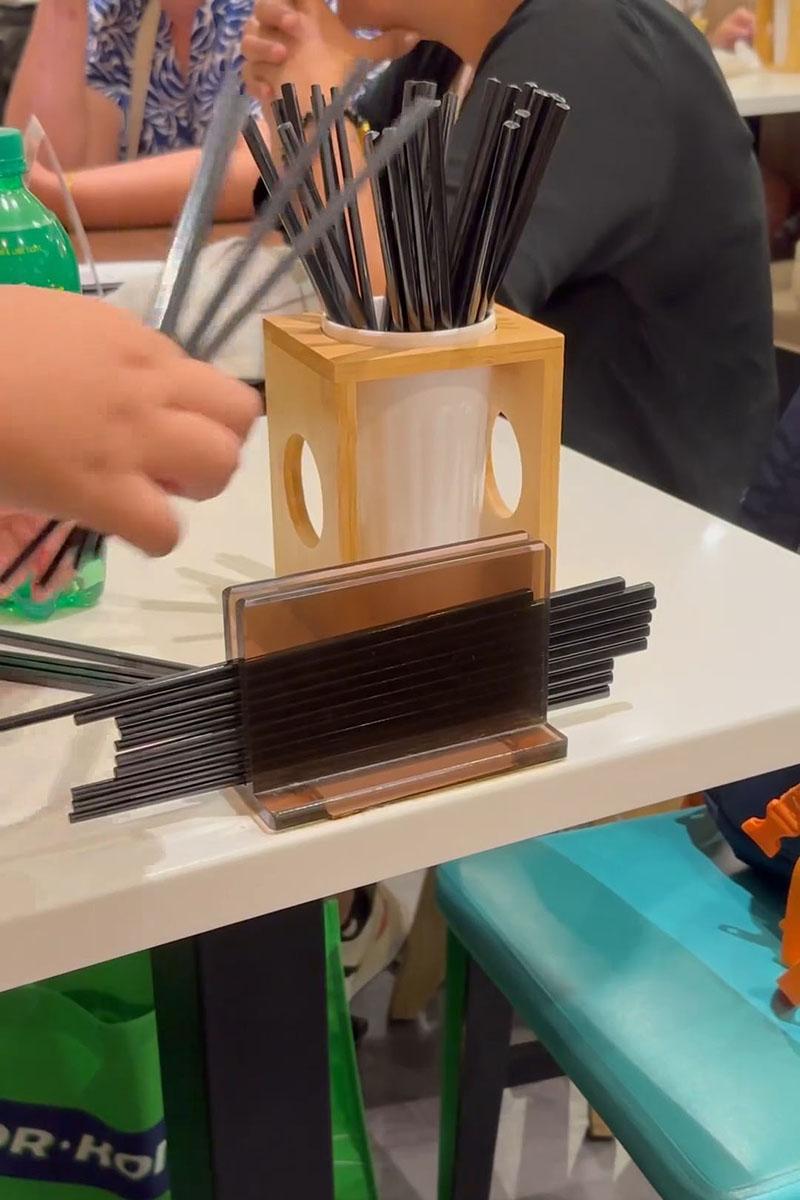 有小孩用食肆自取筷子疊起當玩具,同枱成年人未見阻止。(Threads影片截圖)