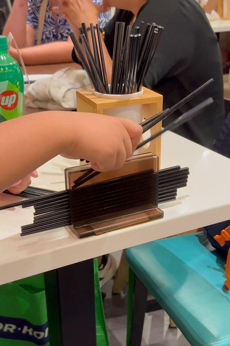 有小孩用食肆自取筷子疊起當玩具,同枱成年人未見阻止。(Threads影片截圖)