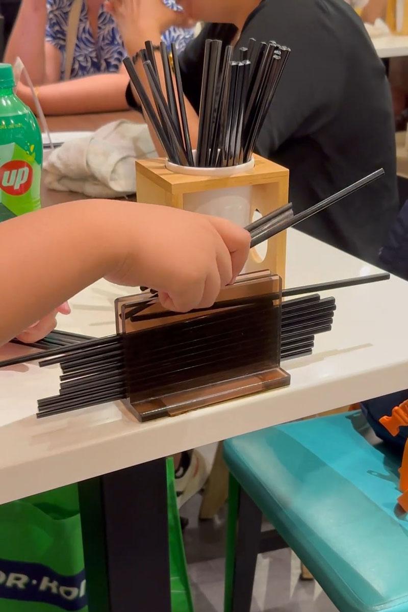 有小孩用食肆自取筷子疊起當玩具,同枱成年人未見阻止。(Threads影片截圖)