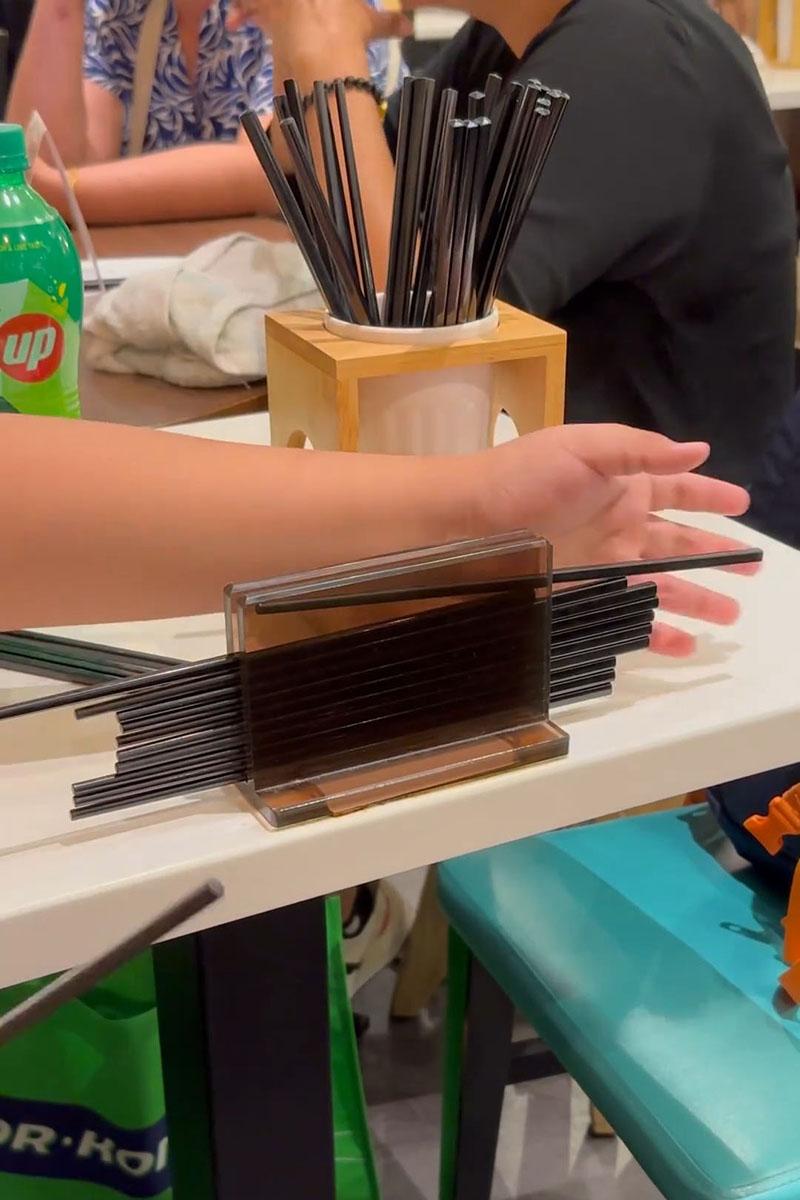 有小孩用食肆自取筷子疊起當玩具,同枱成年人未見阻止。(Threads影片截圖)