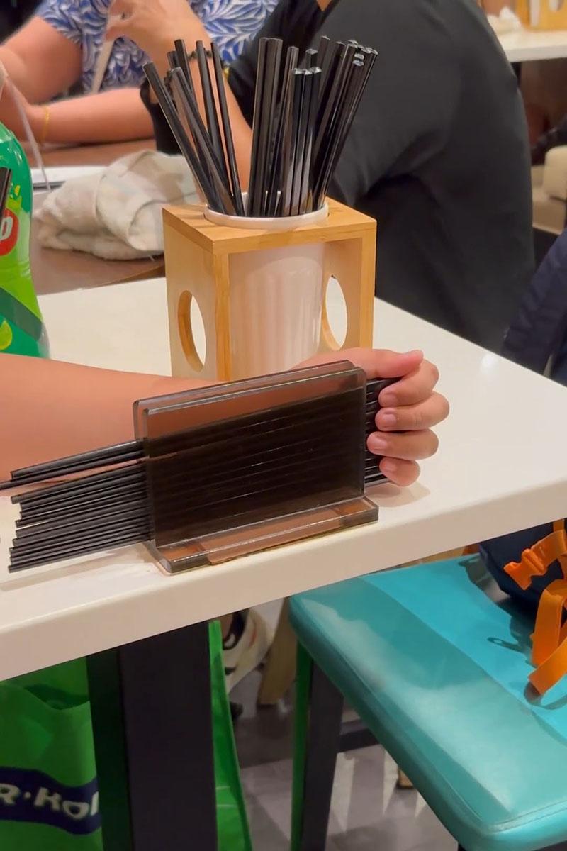 有小孩用食肆自取筷子疊起當玩具,同枱成年人未見阻止。(Threads影片截圖)