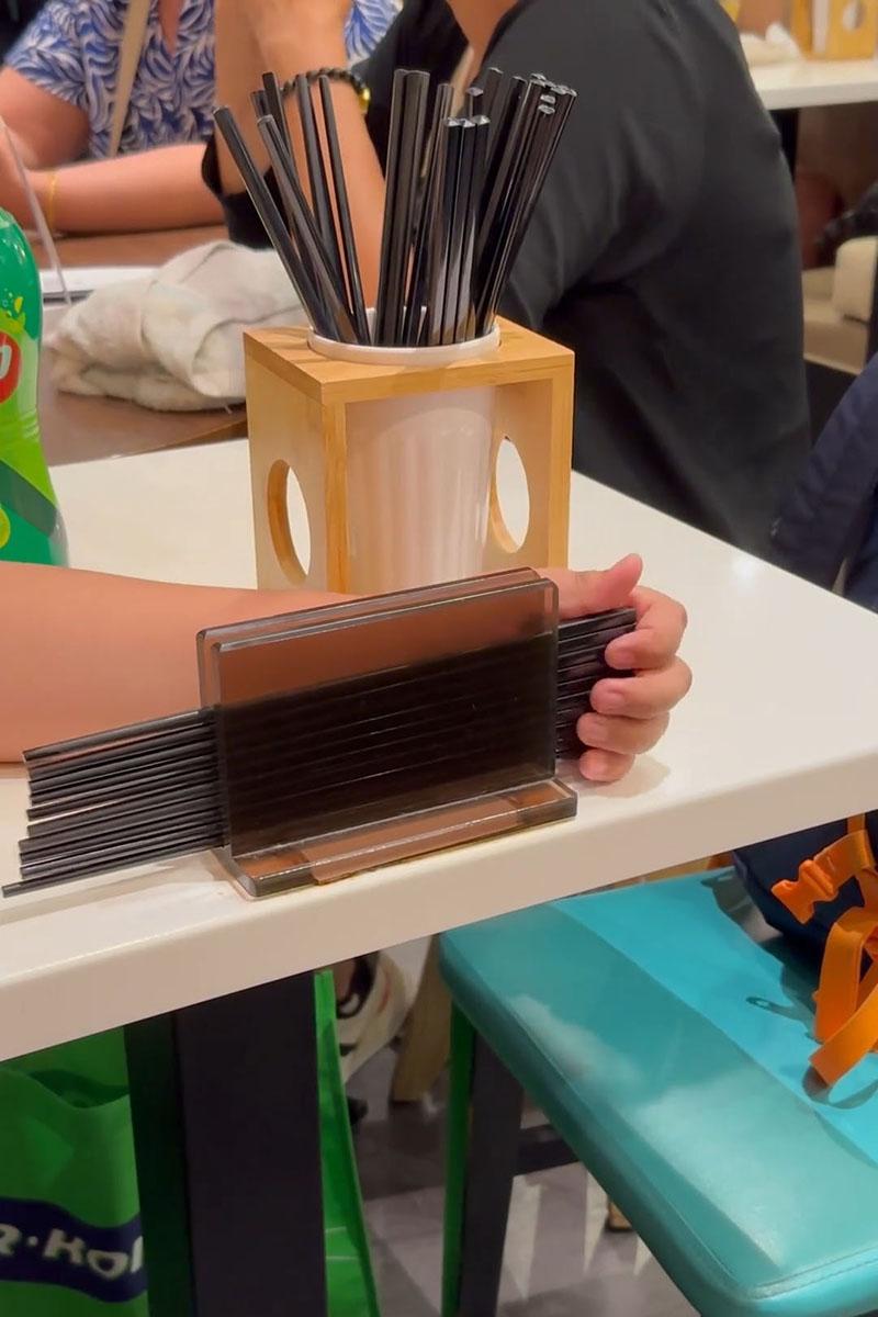 有小孩用食肆自取筷子疊起當玩具,同枱成年人未見阻止。(Threads影片截圖)