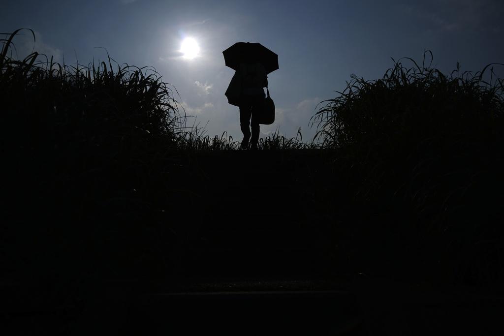 川崎有民眾外出時撐傘。(美聯社)