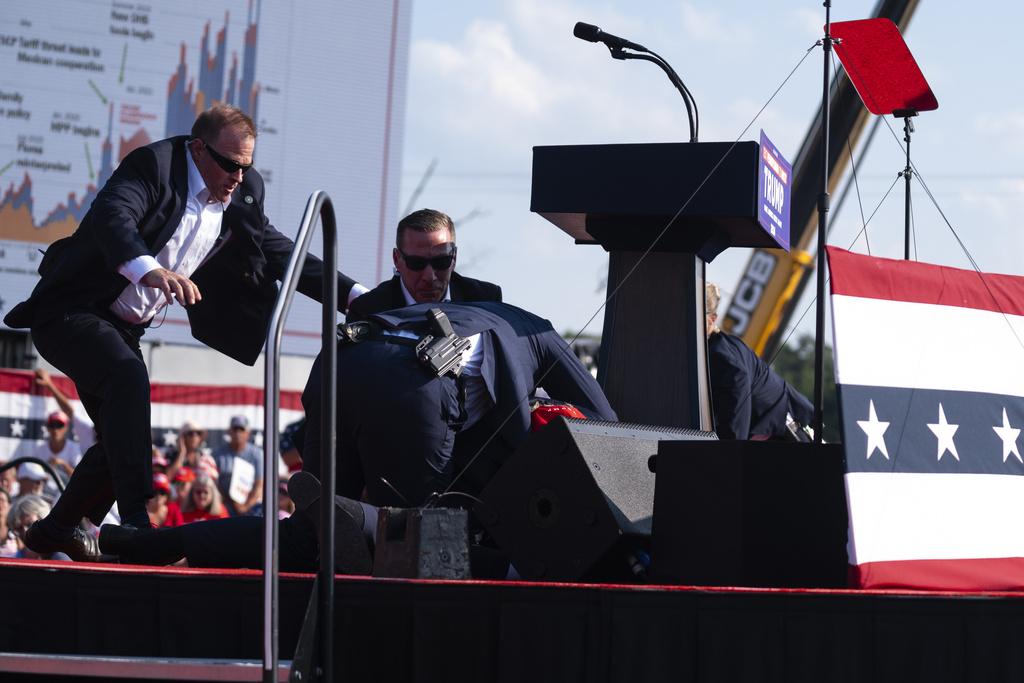 特朗普中槍後伏下,特勤人員衝上台以身體掩護他。(資料圖片)