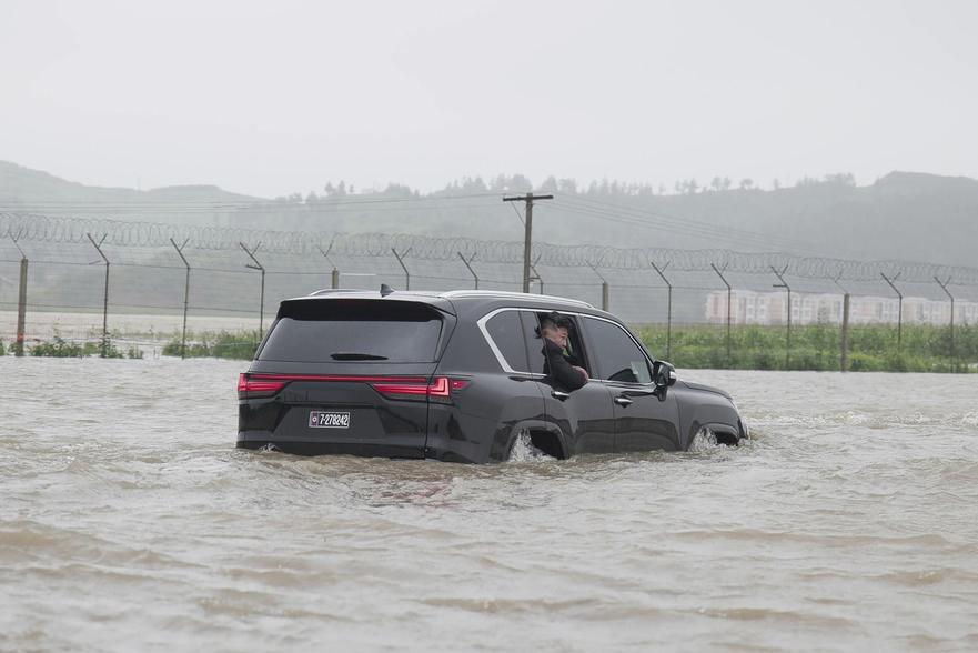 金正恩乘坐座駕亦被洪水圍困,水深至車胎。(朝中社)