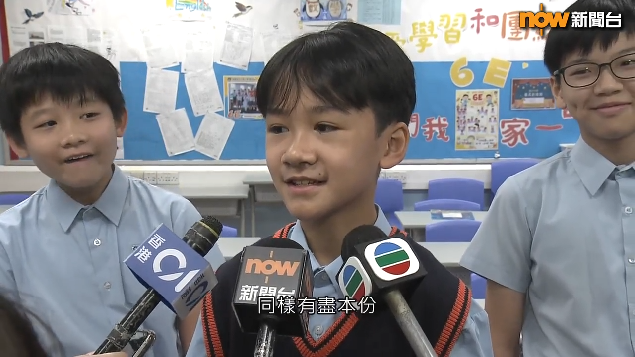 油蔴地天主教小學(海泓道)三位同學接受訪問影片,身後兩名同學的表現非常搞笑。(Now新聞影片截圖)