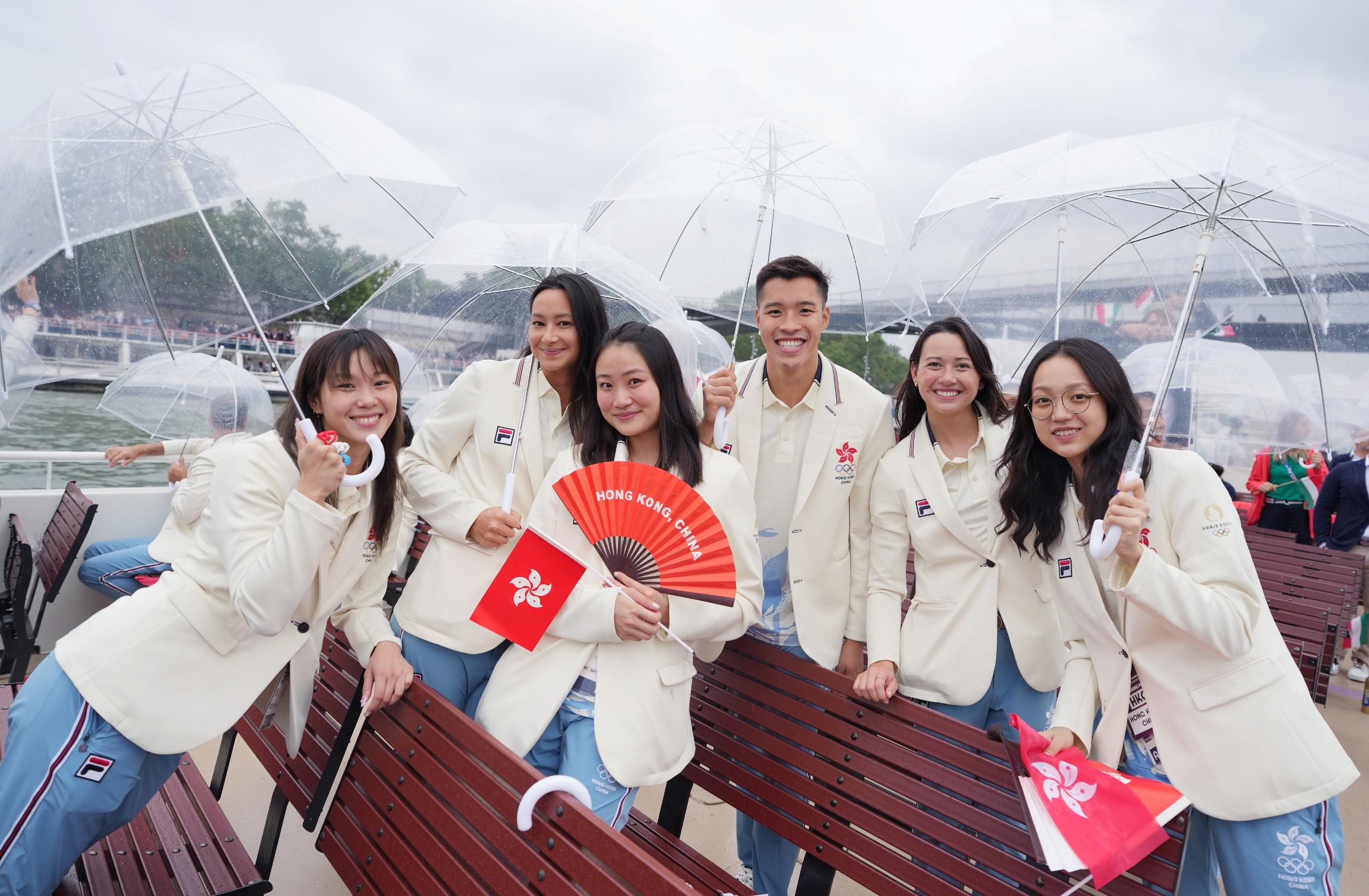開幕禮現場有雨,故港隊運動員巡遊時都需要撐傘避雨。(新華社)