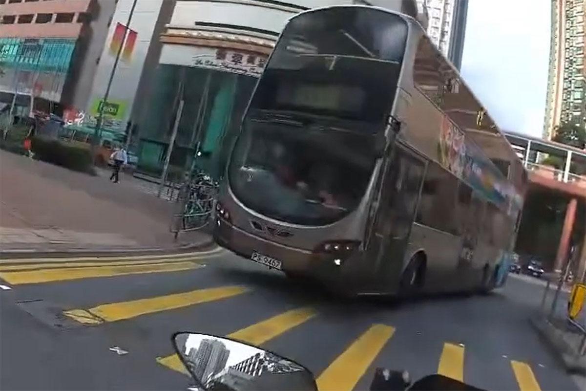 一輛九巴逆線駛入源順圍,險撞到燈位前的電單車。(網上影片截圖)