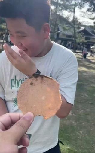 日本網民拿著「大便鹿仙貝」追著一名少年。(互聯網)