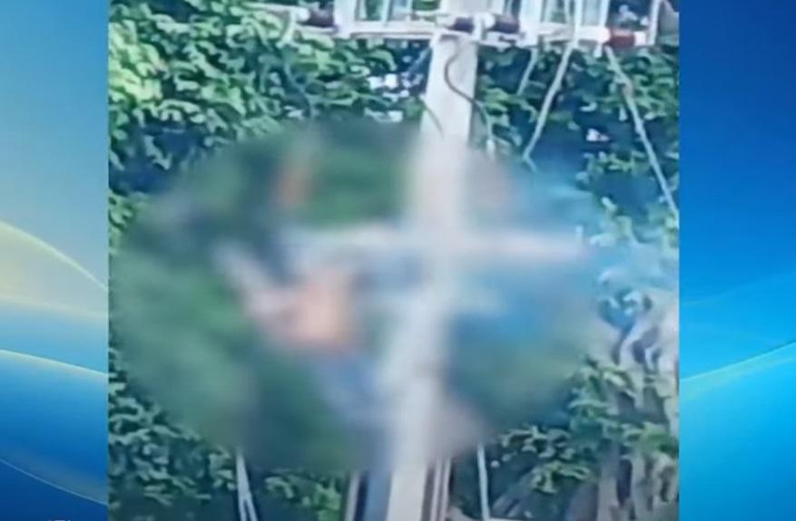 穿橙衣的工人在電線桿上觸電,一路冒煙,一路揮手掙扎。(互聯網)