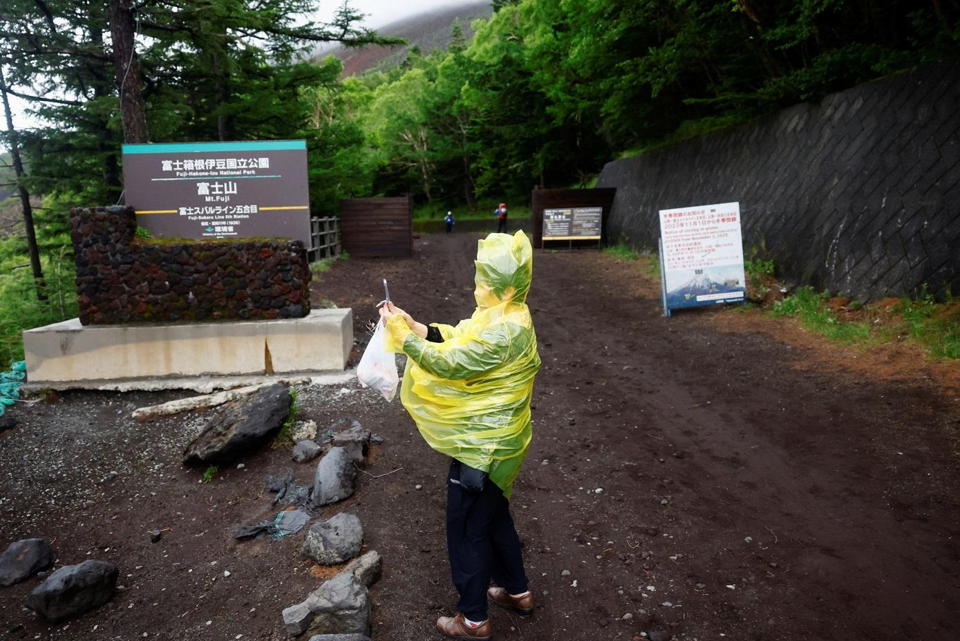 登山客在富士吉田口登山步道閘門前打卡。(路透社)