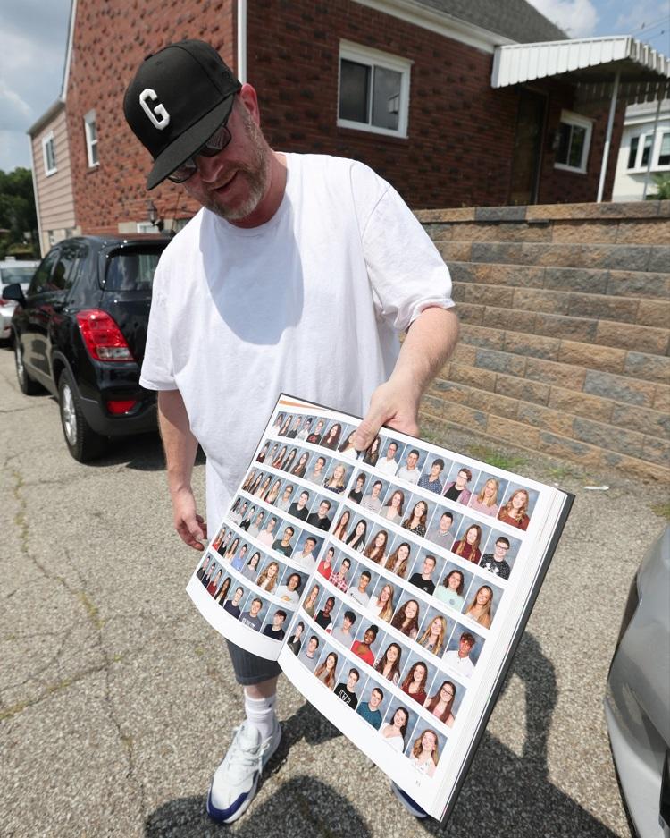 居民展示高中畢業冊上的槍手照片。(路透社)