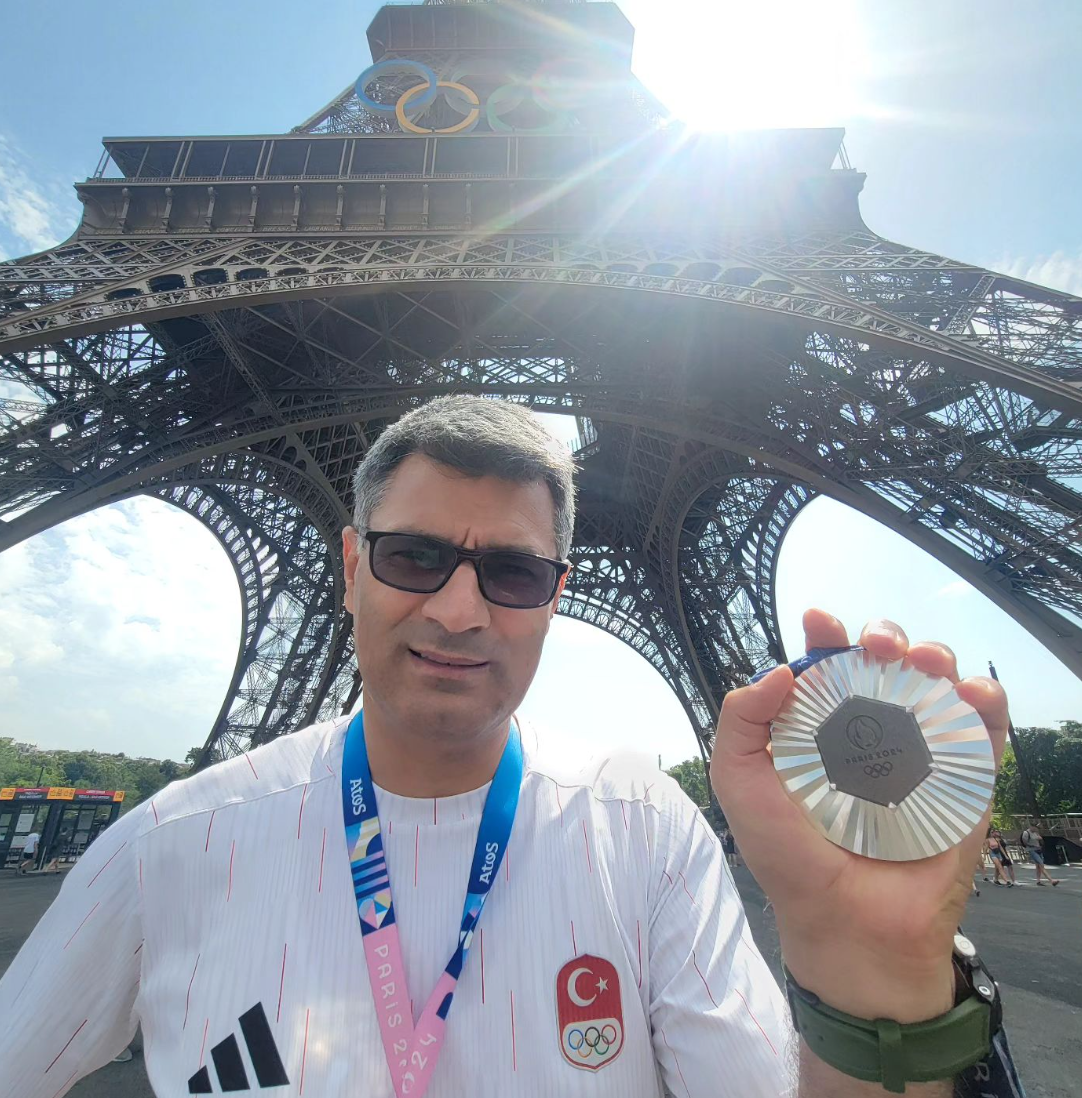 51歲土耳其選手迪凱奇(Yusuf Dikec)在沒有輔助眼鏡、護耳等裝備下,以單手插褲袋姿勢「氣定神閒」出戰混雙10米氣手槍比賽奪銀。(網上圖片)