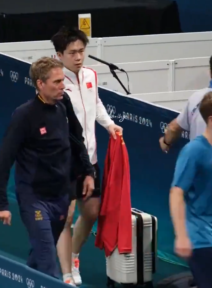 王楚欽出局後接受內媒訪問,離開訪問區時被一名持相機的女攝影記者迎面而至撞倒,對方未有表歉意繼續向前走,王楚欽流露一臉不滿表情,但未有「爆發」無奈離開。(影片截圖)