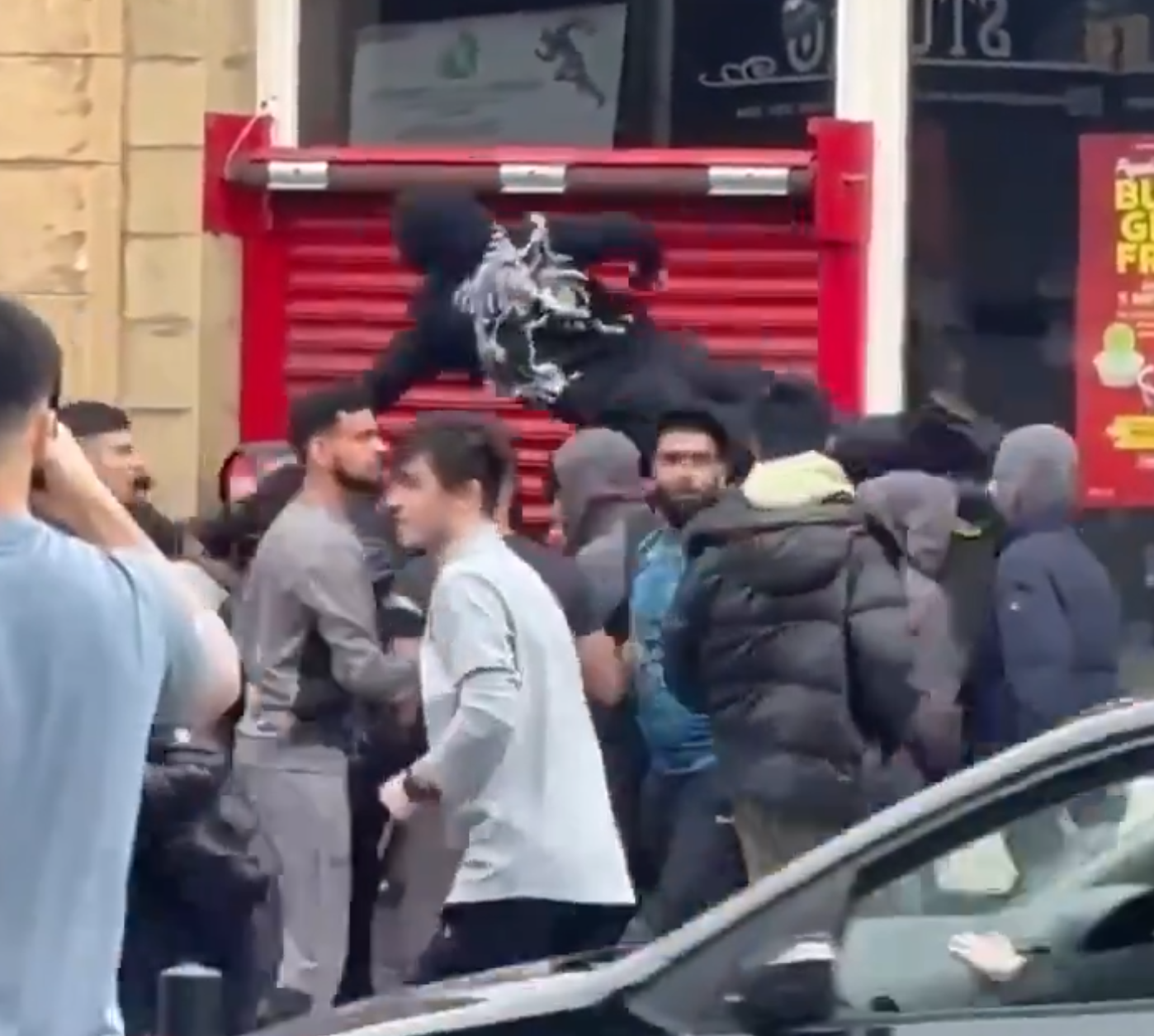 英極右反移民示威|一名男子於街頭被多人圍攻,部分人手持武器。