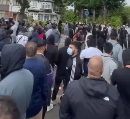 伯明翰周一晚流傳會有右翼團體發起示威,大批穿黑衫民眾於一間連鎖快餐店外聚集戒備(影片截圖)