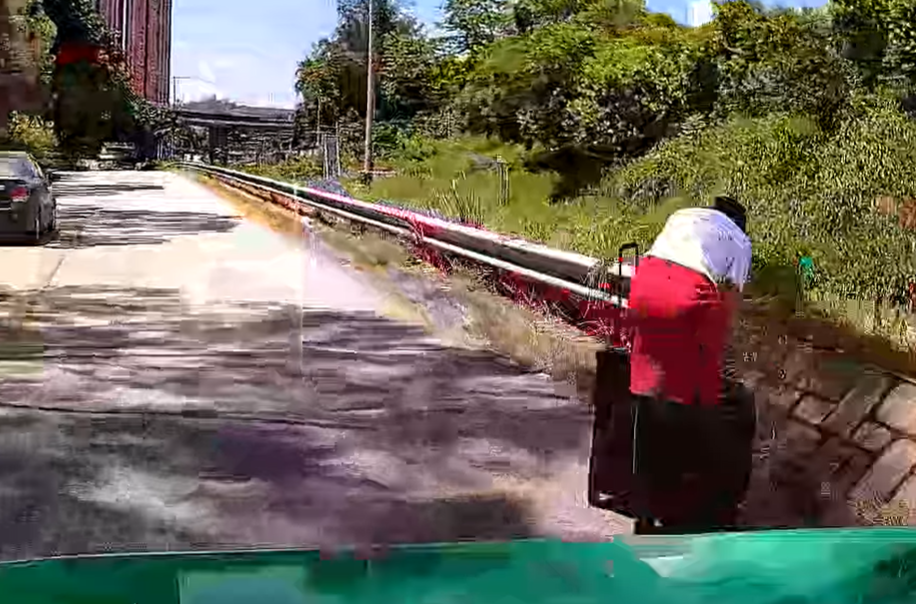 一輛綠色的士於屯門青雲路行駛期間,前方突出現一名帶行李喼的國泰女空姐。(影片截圖)