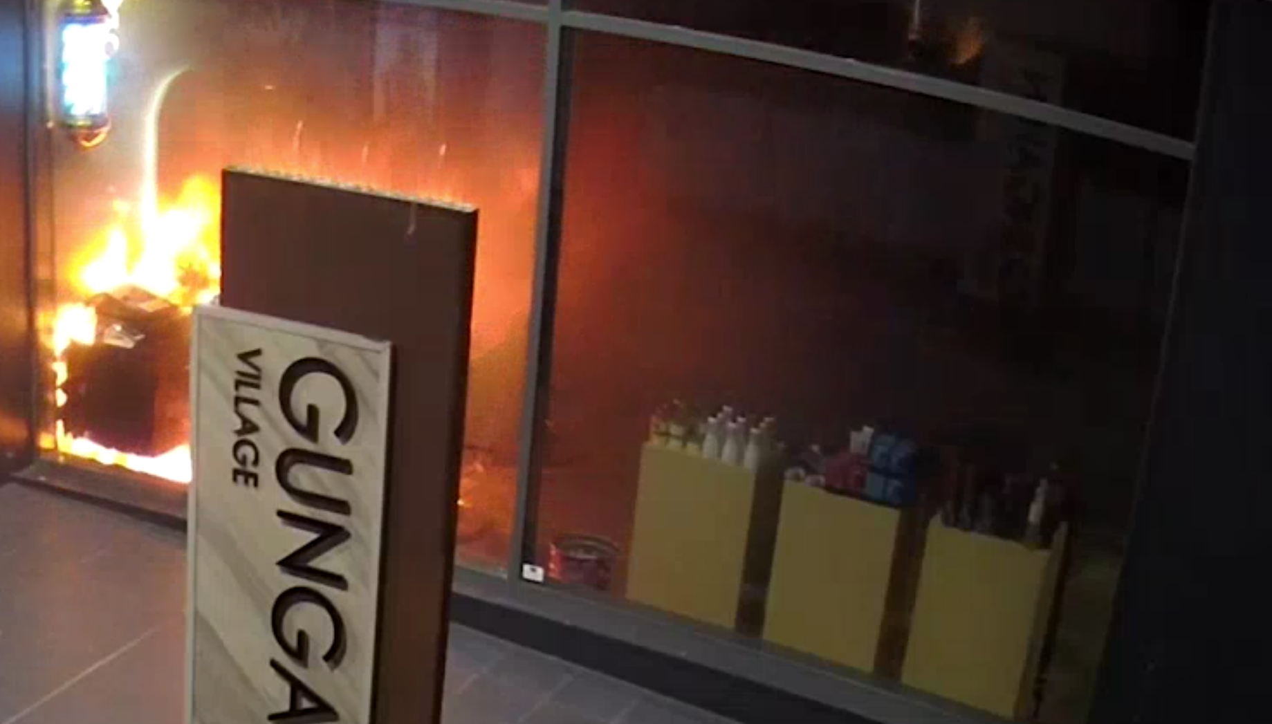 澳洲坎培拉兩男潛入一間髪型屋內縱火,其中一人淋油時火勢瞬間燒至自己身上,立刻衝出店外翻地打滾,及後與同伴狼狽離開,警方正通緝二人,又指幸好事件沒釀傷亡。(影片截圖)