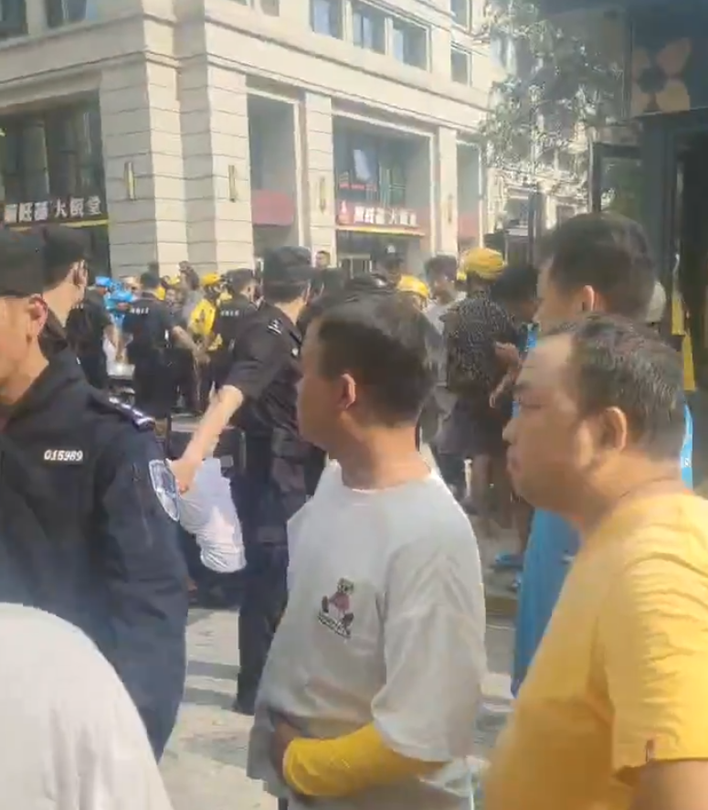 事發後引發數百名騎手聚集示威,要求涉事保安道歉,大批公安介入處埋,及後護送涉事保安離開。(影片截圖)