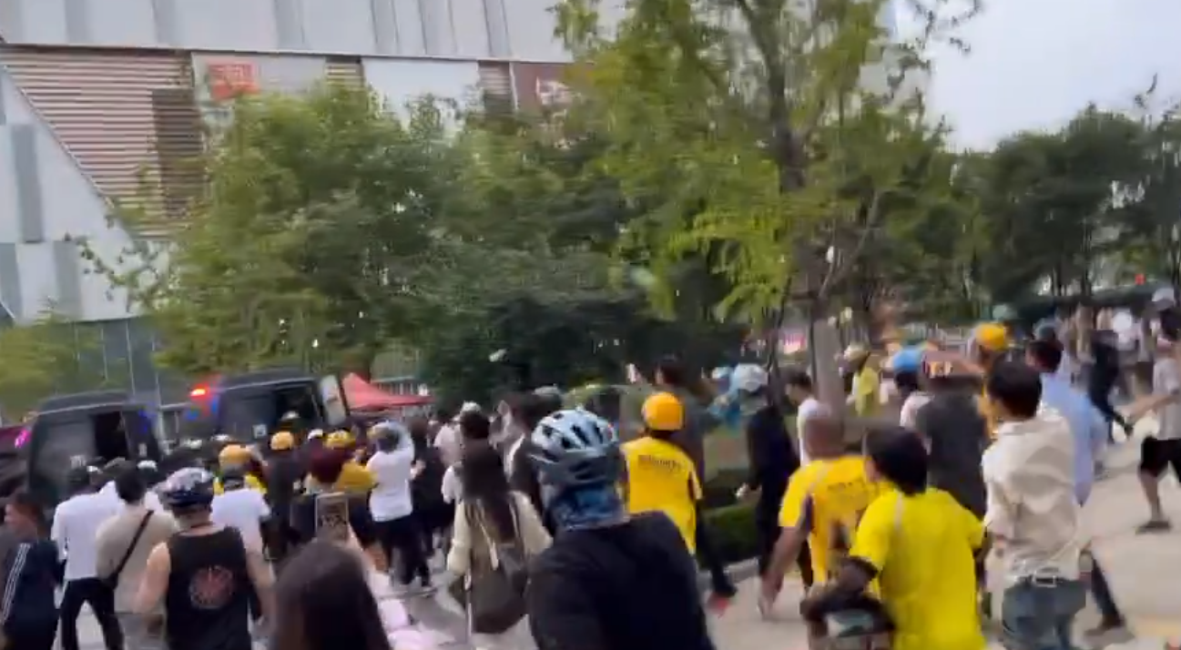 事發後引發數百名騎手聚集示威,要求涉事保安道歉,大批公安介入處埋,及後護送涉事保安離開。(影片截圖)