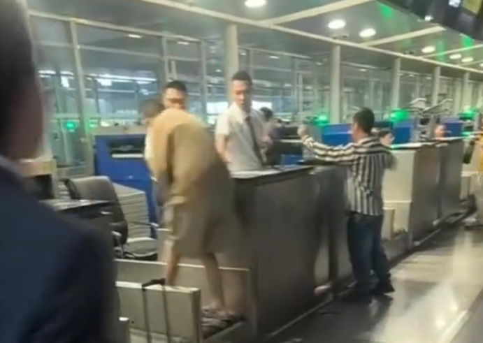 上海浦東機場有乘客因遲到未能乘搭原定航班,在航空公司櫃檯情緒失控,毆打機場地勤人員,遭公安行政拘留。(影片截圖)