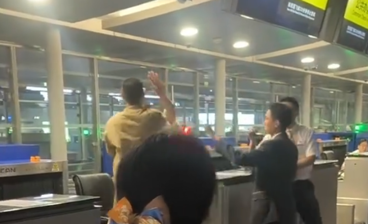 上海浦東機場有乘客因遲到未能乘搭原定航班,在航空公司櫃檯情緒失控,毆打機場地勤人員,遭公安行政拘留。(影片截圖)