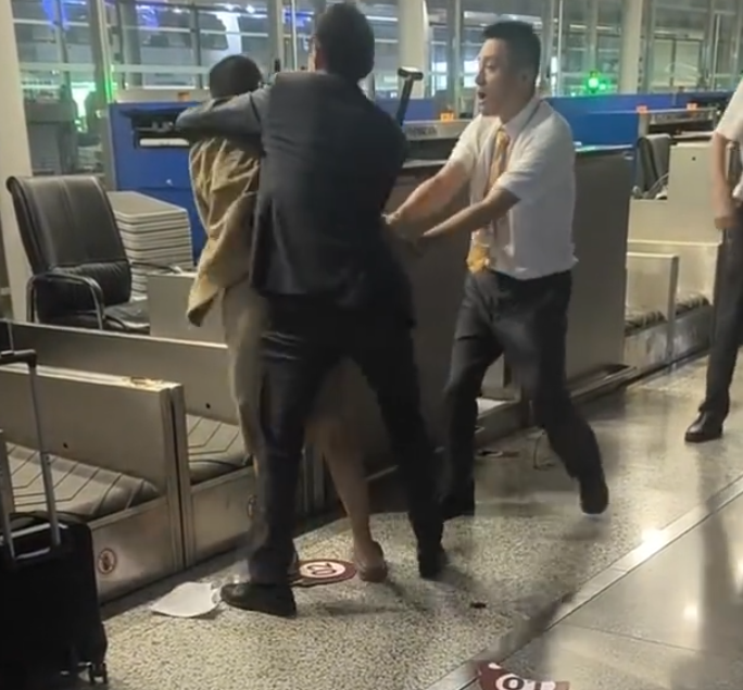 上海浦東機場有乘客因遲到未能乘搭原定航班,在航空公司櫃檯情緒失控,毆打機場地勤人員,遭公安行政拘留。(影片截圖)