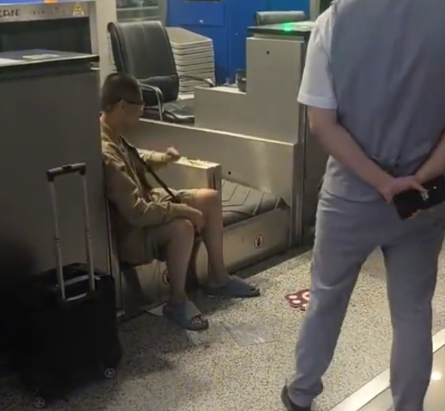 上海浦東機場有乘客因遲到未能乘搭原定航班,在航空公司櫃檯情緒失控,毆打機場地勤人員,遭公安行政拘留。(影片截圖)