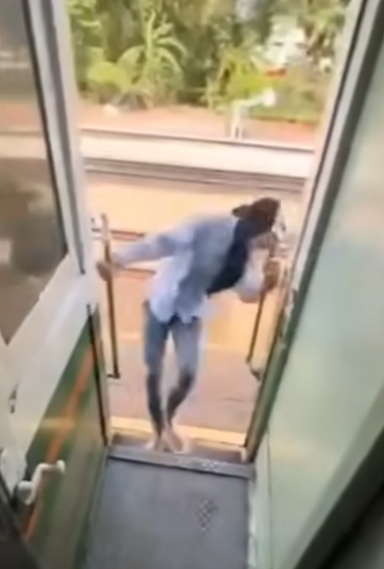 該名女子在火車行駛期間站在敞開的車門梯級,雙手扶住欄杆身體向後傾,及後頭部撞到車外一條柱,她一度失平衡但仍緊握扶手。(影片截圖)