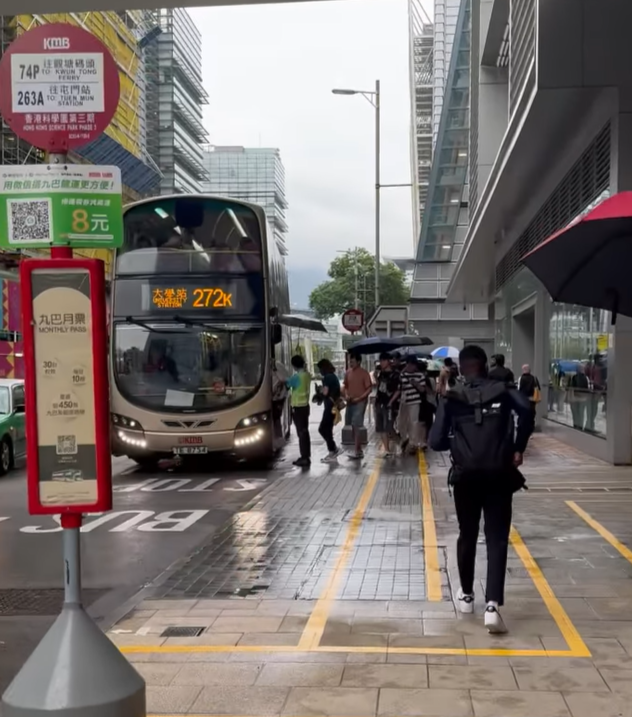 在科學園272K線往大學站的車站,大批乘客正排隊準備上車,該名九巴職員於車門「擔遮」,方便乘客提早收傘上車,亦避免遭淋濕。(社交平台Threads)