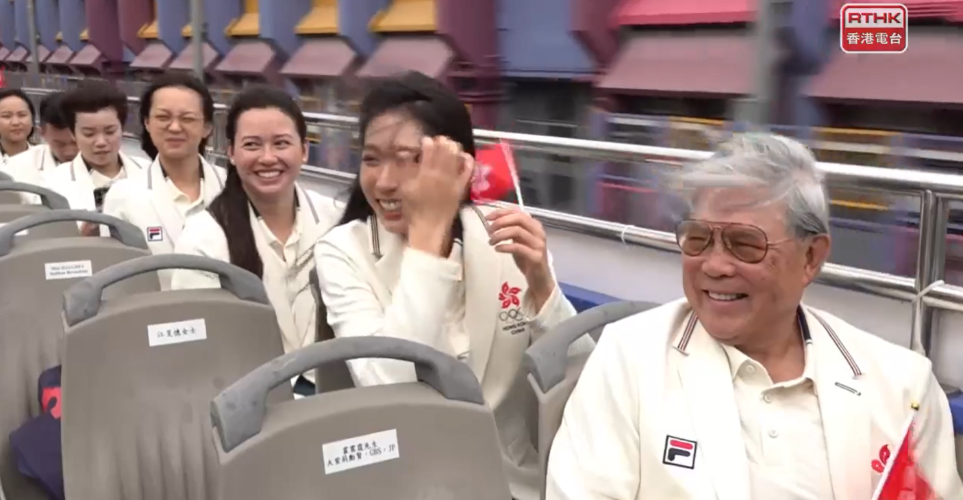 巴黎奧運港隊巡遊坐在開篷巴士上,眾人的秀髮亂了。(網上直播畫面截圖)