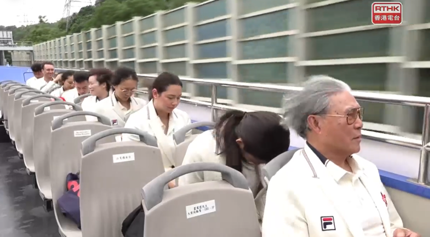 巴黎奧運港隊巡遊坐在開篷巴士上,眾人的秀髮亂了。(網上直播畫面截圖)