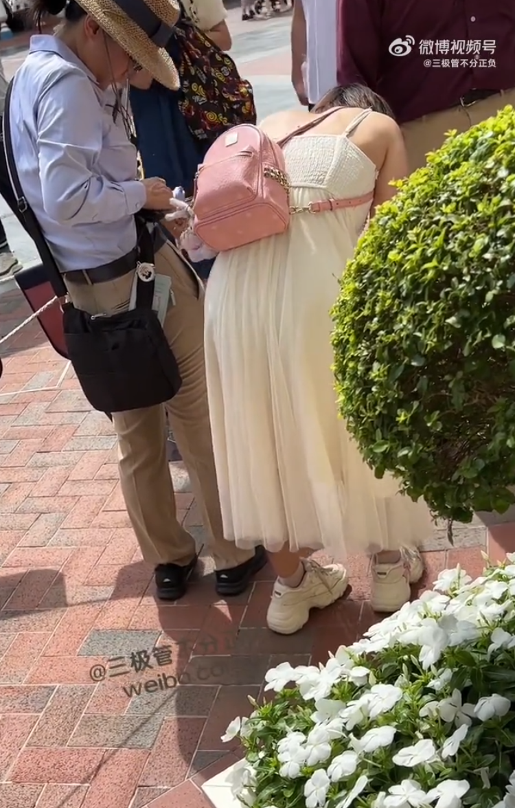 上海迪士尼一名女遊客排隊等候遊玩項目期間去廁所,因超過了規定的20分鐘「廁所卡」時限,與工作人員發生爭執不果後崩潰大哭。(影片截圖)