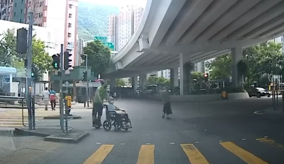 筲箕灣一名男子推一名坐輪椅的長者時踩「風火輪」馳騁過馬路。YouTube頻道「車CAM特警」