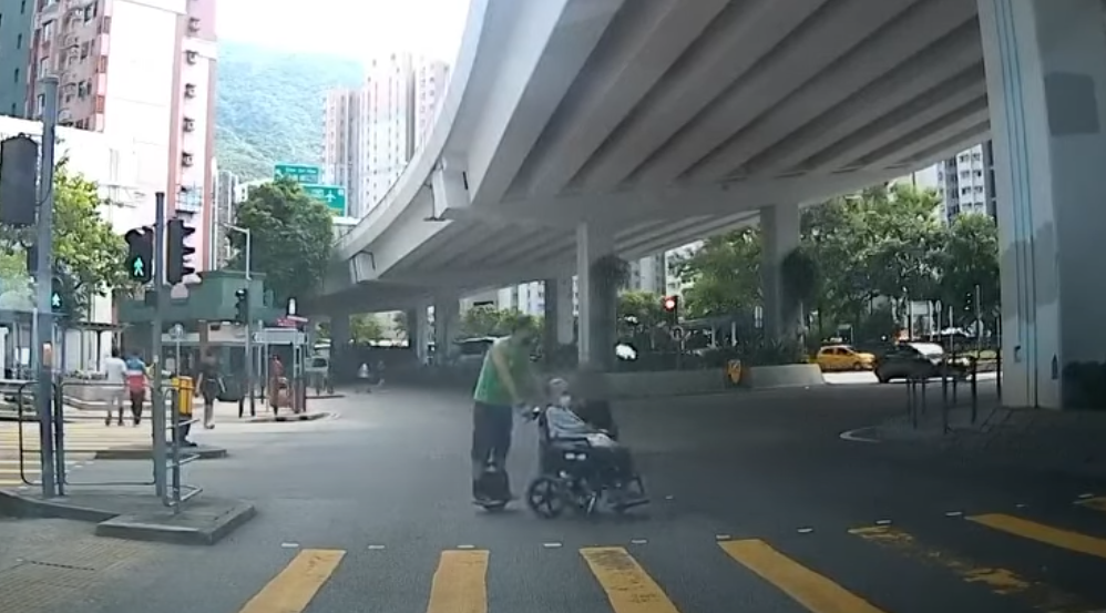 筲箕灣一名男子推一名坐輪椅的長者時踩「風火輪」馳騁過馬路。YouTube頻道「車CAM特警」