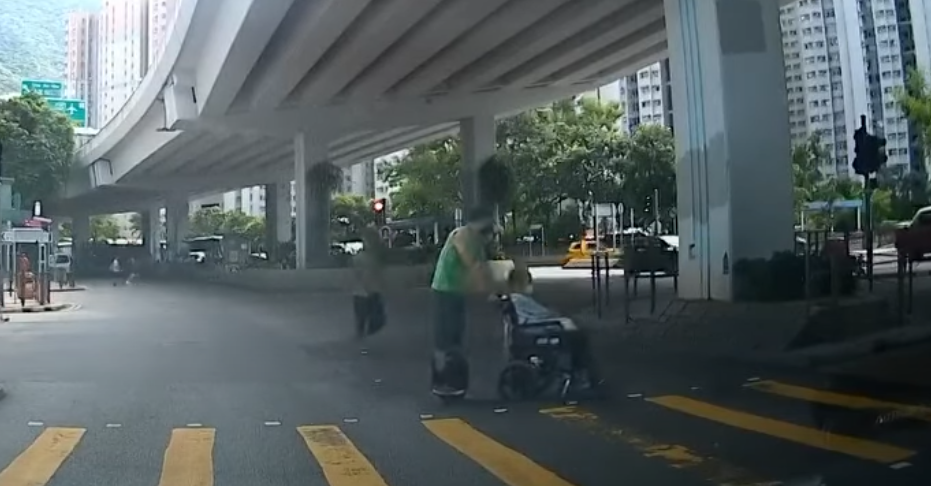 筲箕灣一名男子推一名坐輪椅的長者時踩「風火輪」馳騁過馬路。YouTube頻道「車CAM特警」