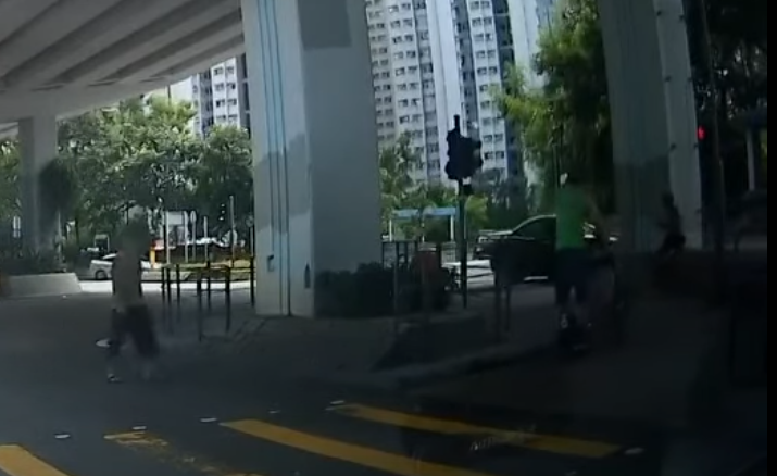 筲箕灣一名男子推一名坐輪椅的長者時踩「風火輪」馳騁過馬路。YouTube頻道「車CAM特警」
