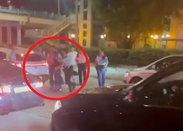 疑犯(紅圈)被多名警員押上警車。(影片截圖)