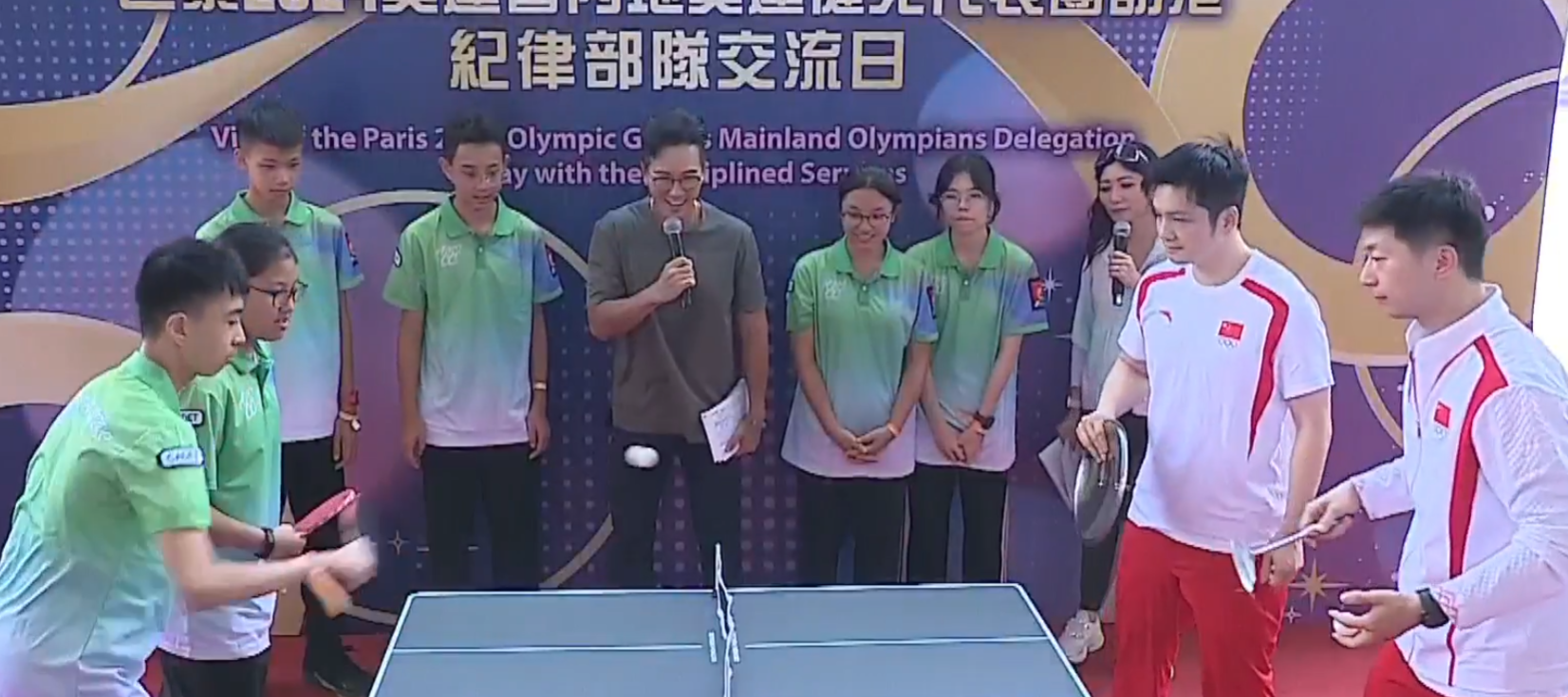 兩名乒乓球選手馬龍、樊振東與青少年較技,為了讓賽,球拍更換成盤子、煲蓋、鑊鏟(電視畫面)