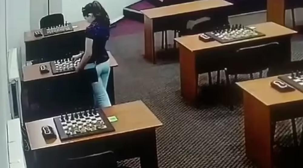 Amina Abakarova試圖用棋子擦拭棋盤來隱藏液體。(X)