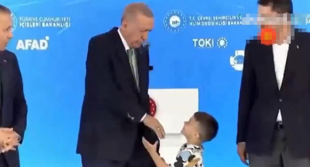 埃爾多安伸出右手讓男童親吻手背,年紀較小的男童面帶笑容一時間沒有意會。(X)