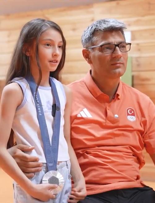 迪凱奇的女兒戴著父親的奧運銀牌,父女互動的過程,可見之間的好感情溢於言表。(X)