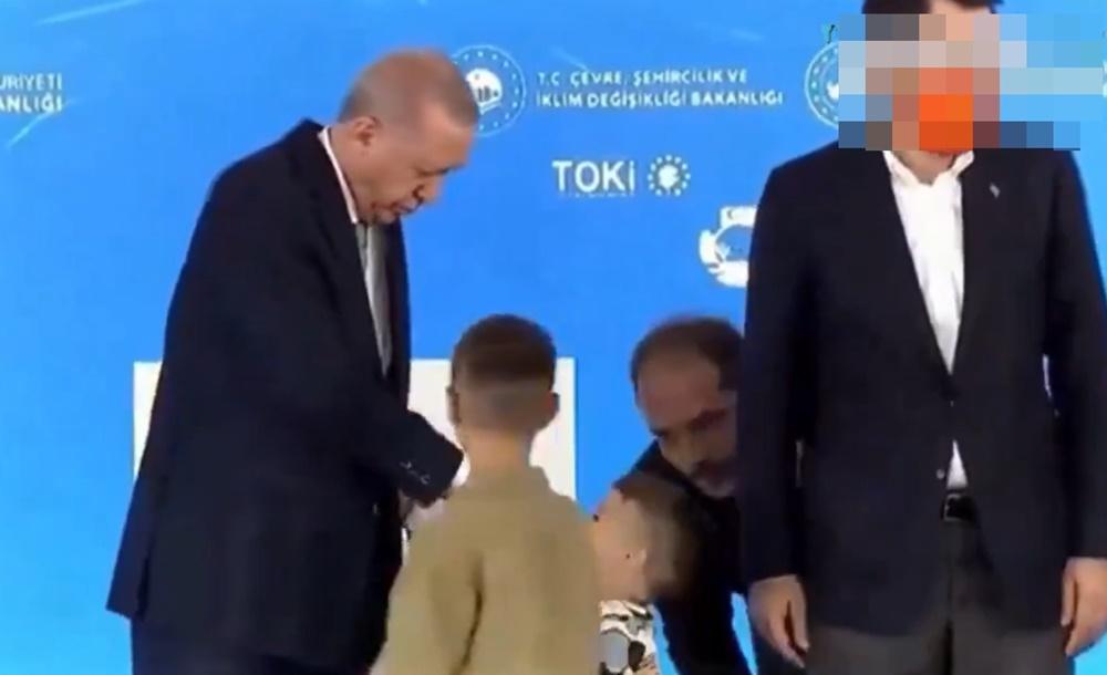 一名幕僚見狀立即俯身在男童耳邊說話疑似提示,男童立即親吻埃爾多安的手背。(X)