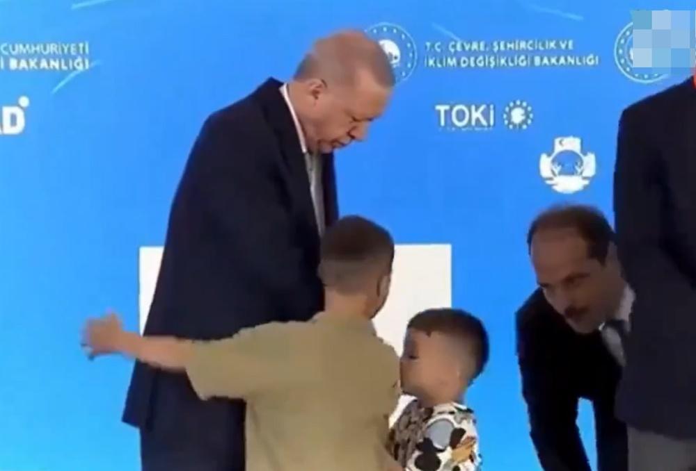 一名幕僚見狀立即俯身在男童耳邊說話疑似提示,男童立即親吻埃爾多安的手背。(X)